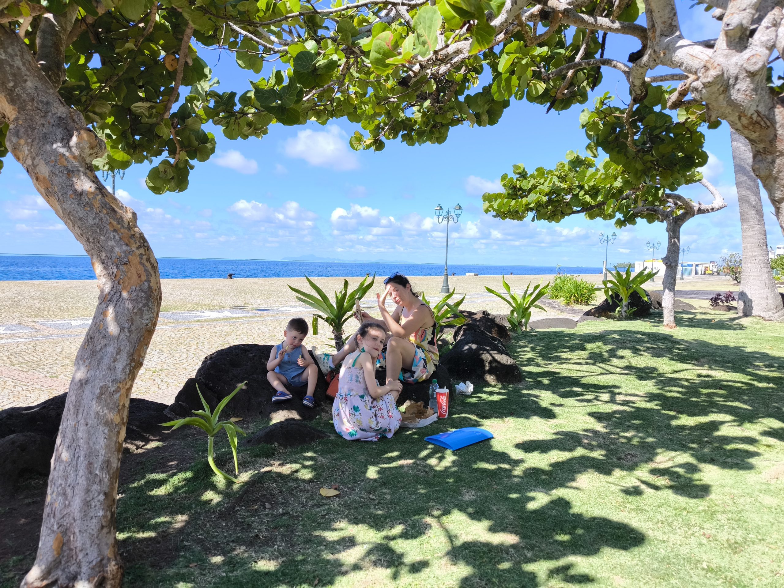Photo d'une mère et de ses deux enfants au bord du lagon