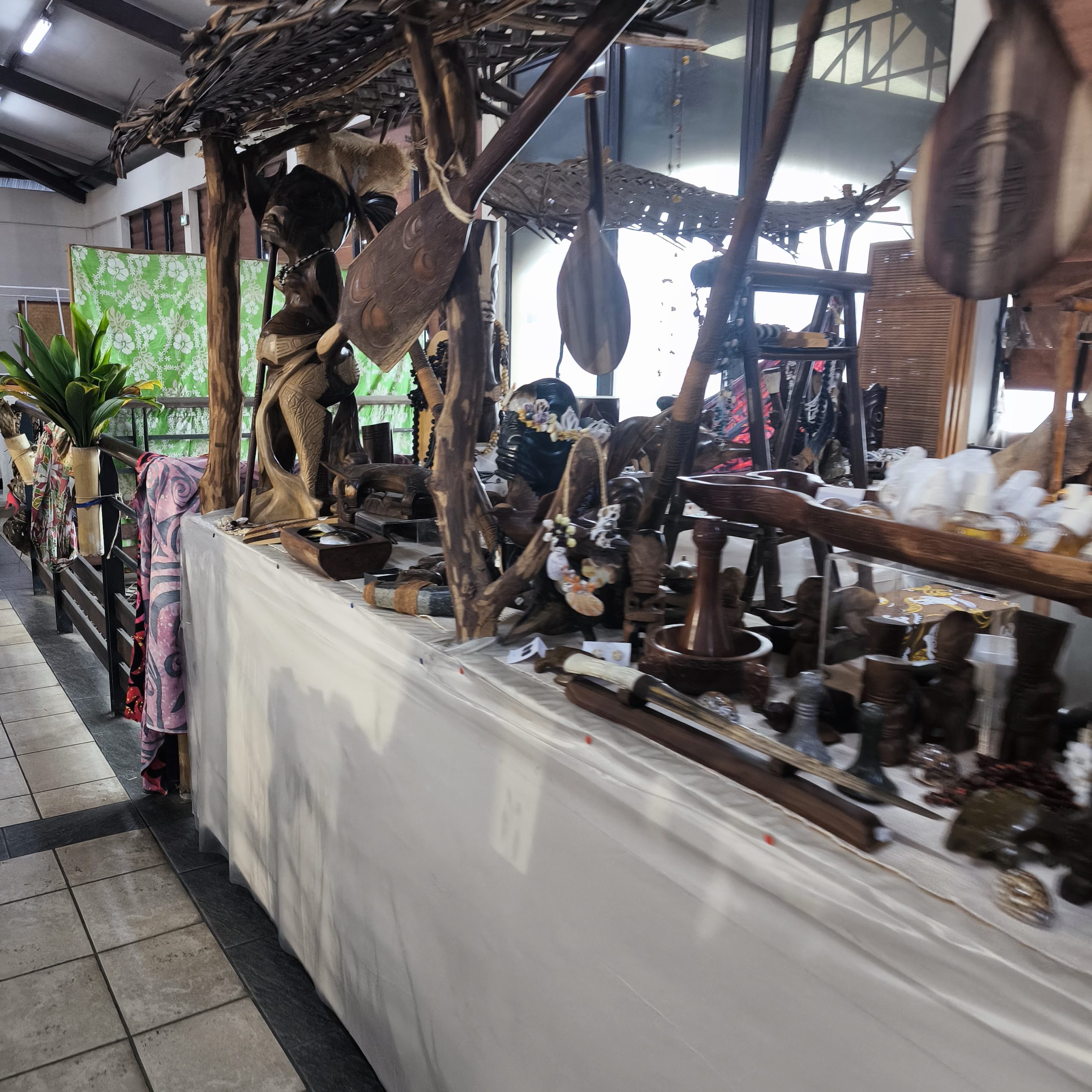 Stand de sculptures en bois et artisanat polynésien au marché d'Uturoa Raiatea
