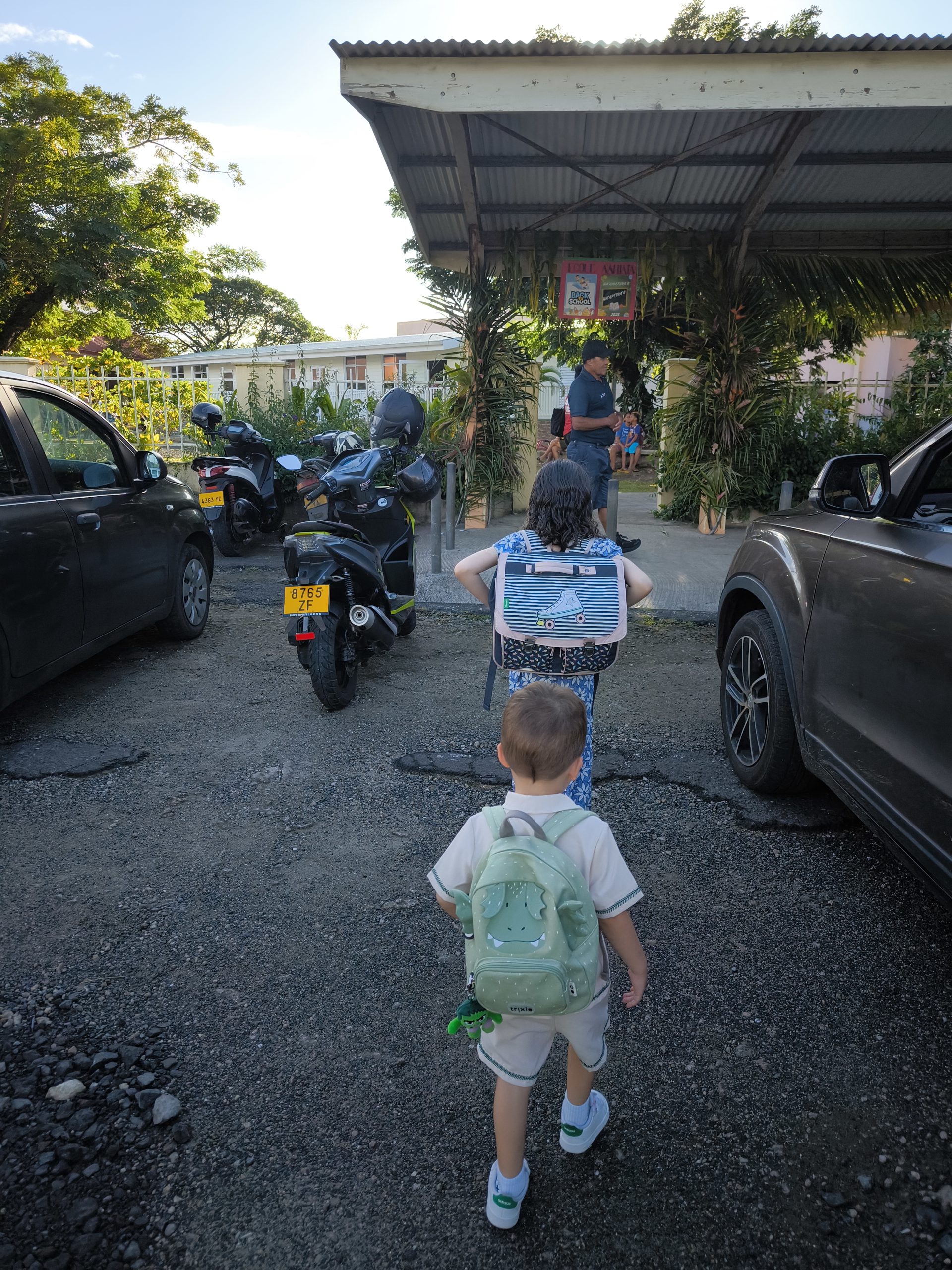 Iris et Amir marchent vers l'entrée de leur école à Raiatea, le jour de la rentrée